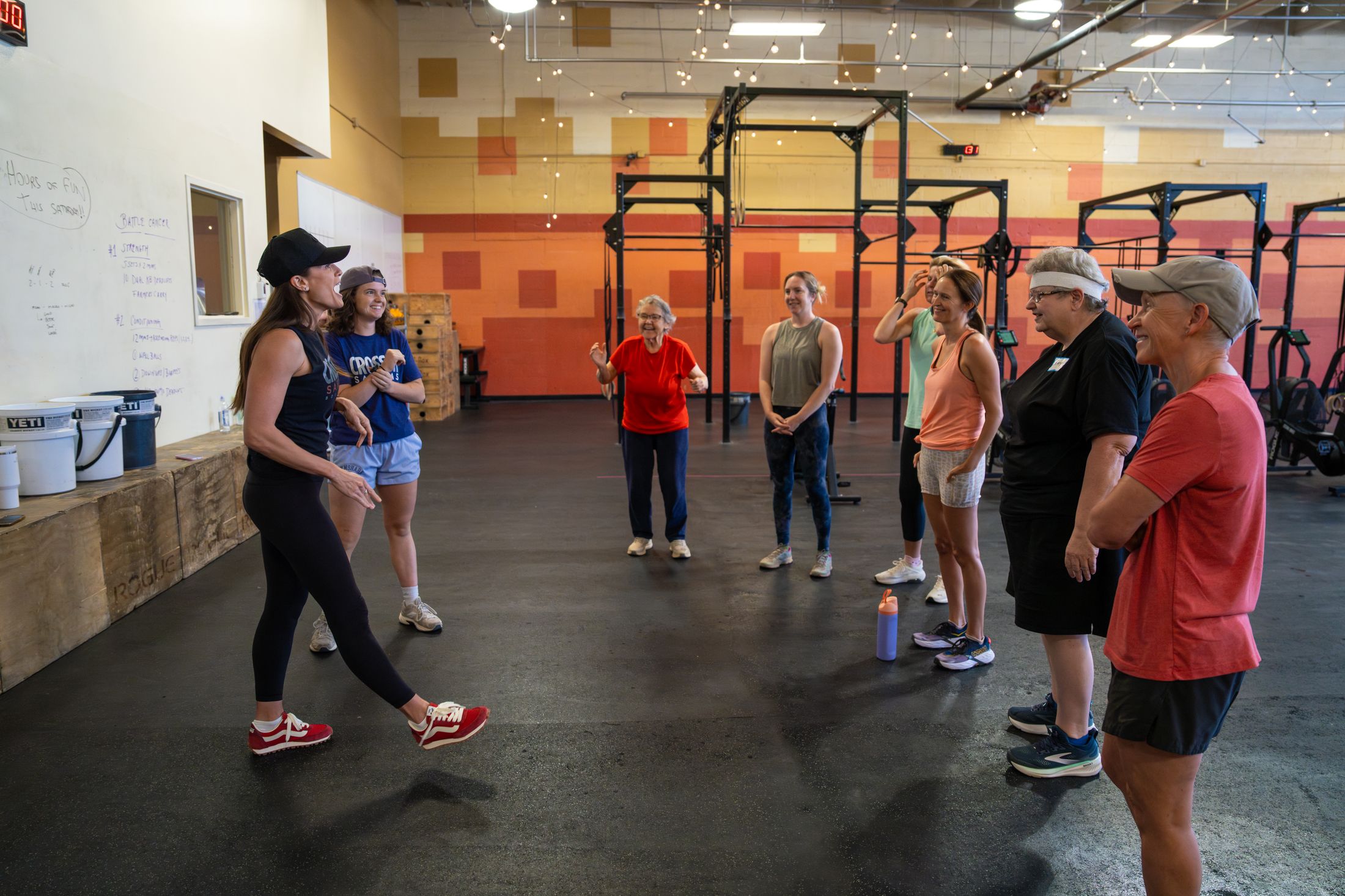 A coach demonstrates a movement for the group in the gym