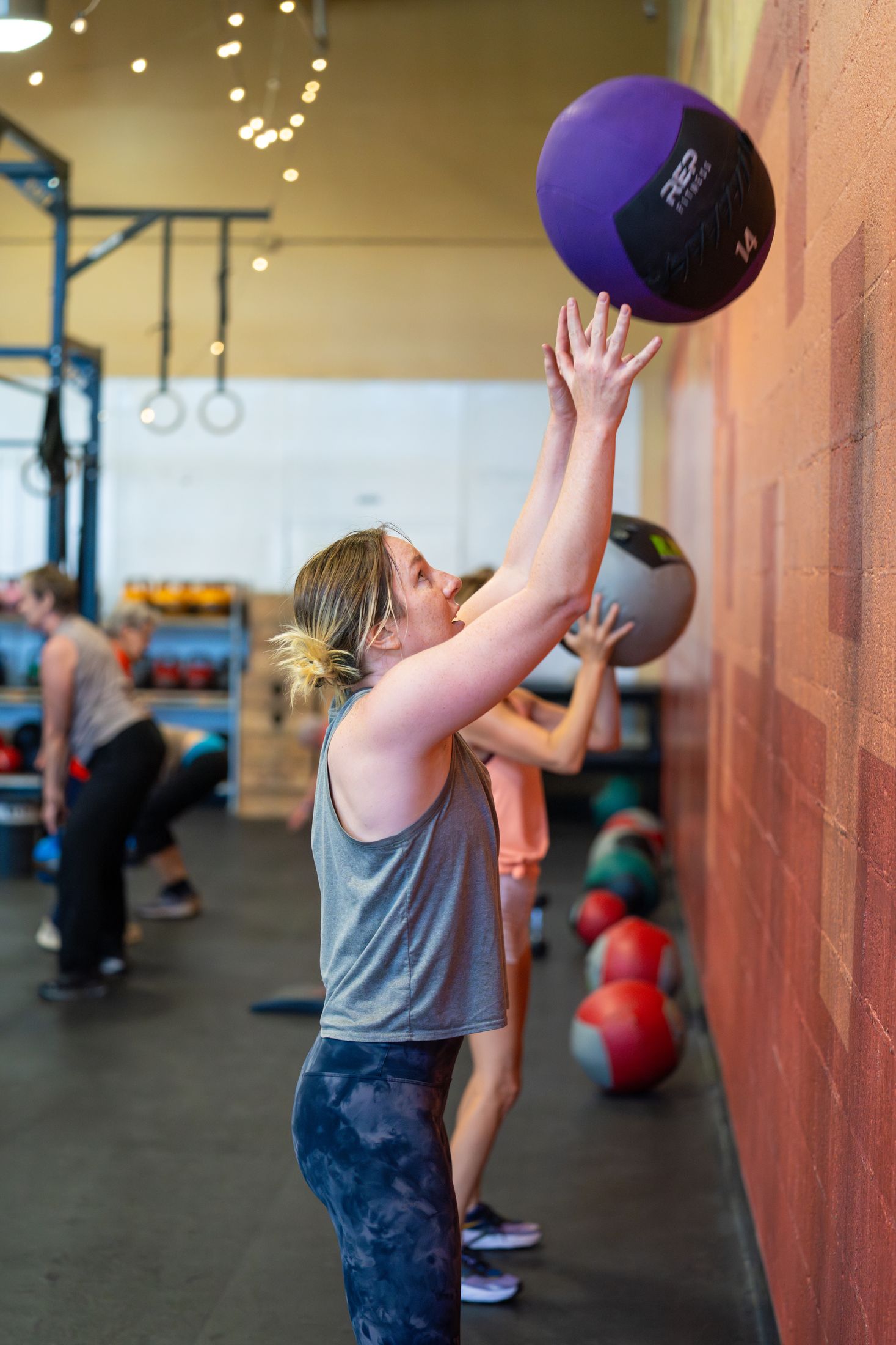 A participant throws a medicine ball toward a wall target